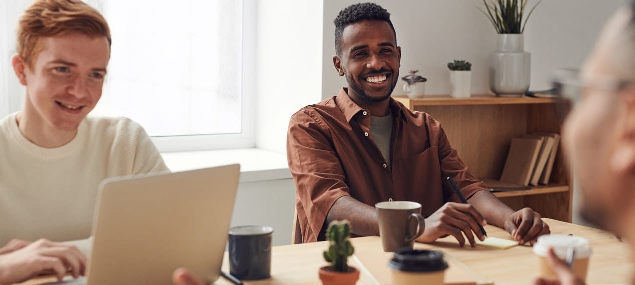 young professionals sitting around a table and smiling